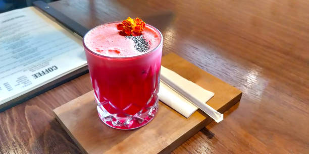 Red Strawberry summer juice refreshment on a wooden platter