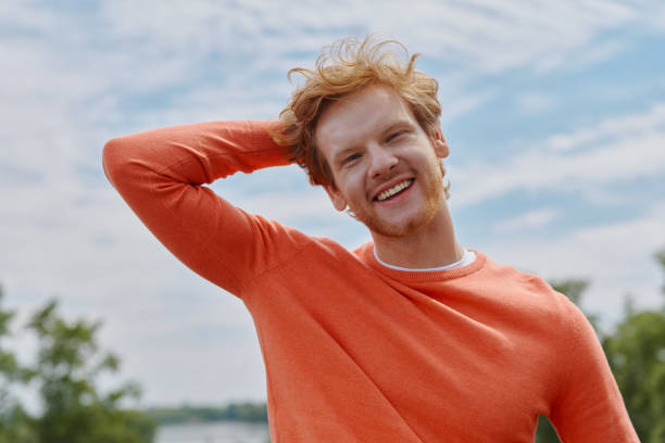 istock Relaxed young redhead man holding hand behind head and smiling 1403084605