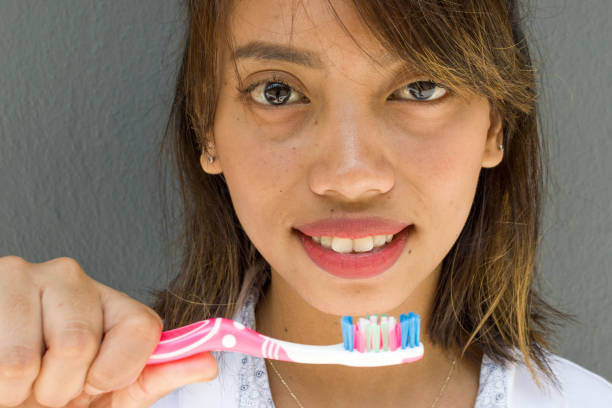 Hands of smile young Asian woman holding toothbrush