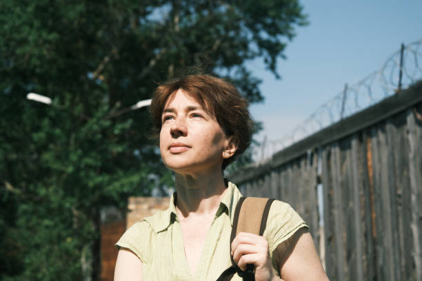 istock Woman is standing next to barbed wire fence 1403085796