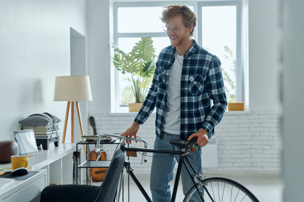 istock Cheerful young man standing near his bicycle at home 1403087027
