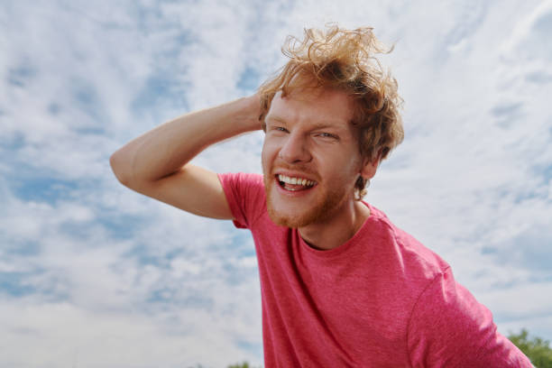 istock Handsome young redhead man looking at camera and smiling with sky in the background 1403087225