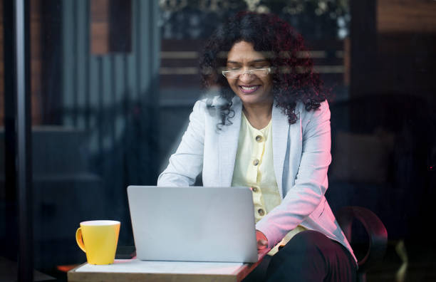 istock Happy businesswoman using laptop at cafe 1403087293