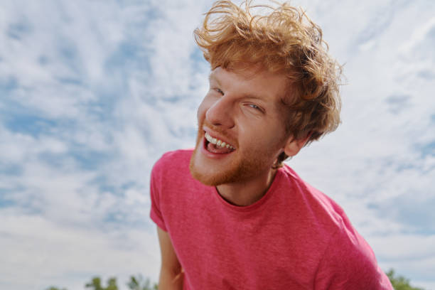 istock Handsome young redhead man looking at camera and smiling with sky in the background 1403087385