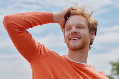 Low angle view of young man meditating outdoors on a cold day.