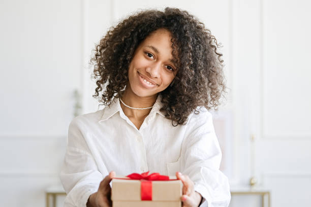 istock Young woman giving gift box with ribbon 1403088810