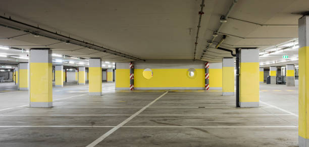 istock Empty underground supermarket parking lot with yellow concrete columns and white stripes for cars 1403088982