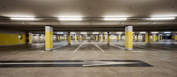 istock Front view empty underground supermarket parking with yellow concrete columns and white arrow on the ground 1403089000