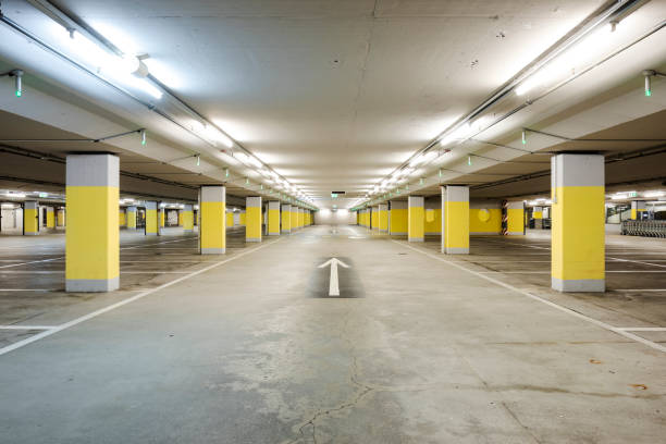 istock Front view empty underground supermarket parking with yellow concrete columns and white arrow on the ground 1403089028