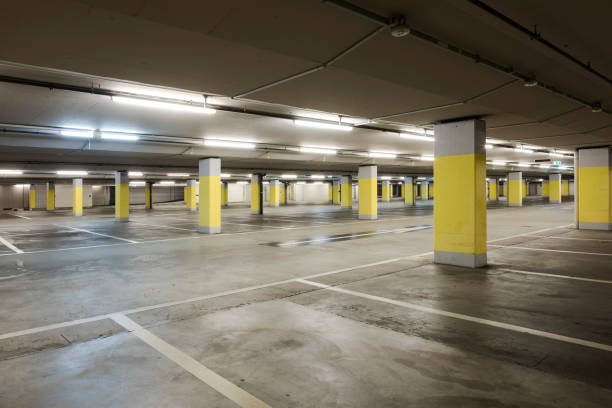 istock Empty underground supermarket parking lot with yellow concrete columns and white stripes for cars 1403089036