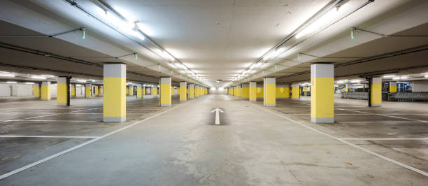 istock Front view empty underground supermarket parking with yellow concrete columns and white arrow on the ground 1403089048