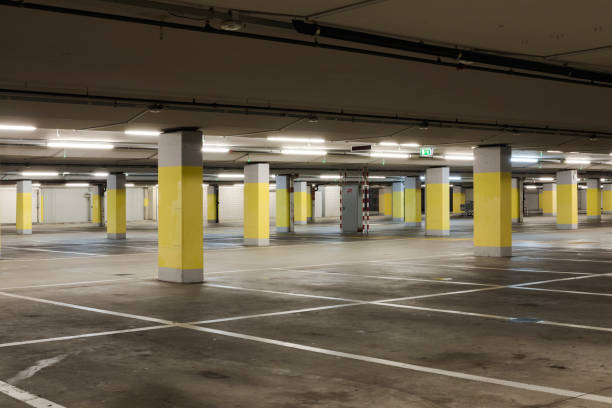 istock Empty underground supermarket parking lot with yellow concrete columns and white stripes for cars 1403089091