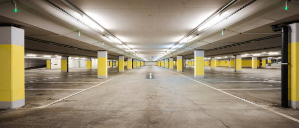 istock Front view empty underground supermarket parking with yellow concrete columns and white arrow on the ground 1403089113