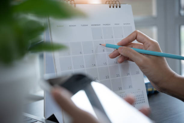 istock Business woman checking planner on mobile phone, taking note on calendar desk on office table 1403090706