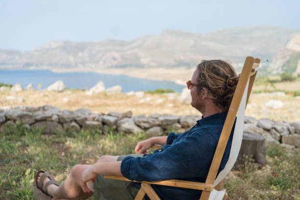 istock Young man relaxes at coastal viewpoint 1403091660