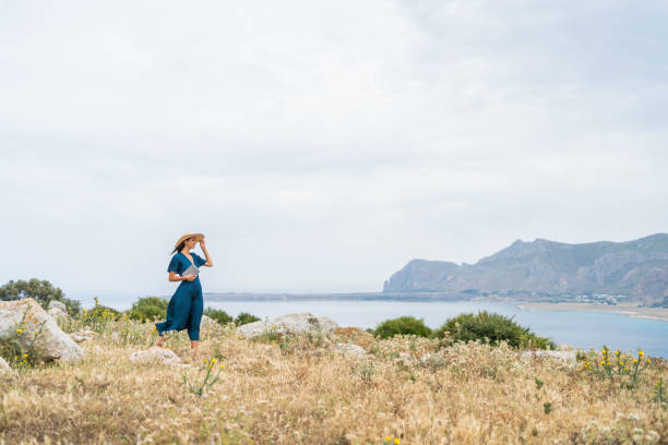 istock Young woman relaxes at coastal viewpoint 1403091817