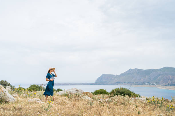 istock Young woman relaxes at coastal viewpoint 1403091827