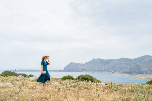 istock Young woman relaxes at coastal viewpoint 1403091835