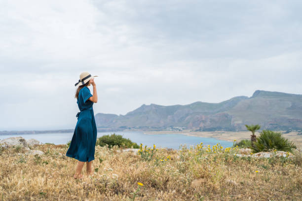 istock Young woman relaxes at coastal viewpoint 1403091851