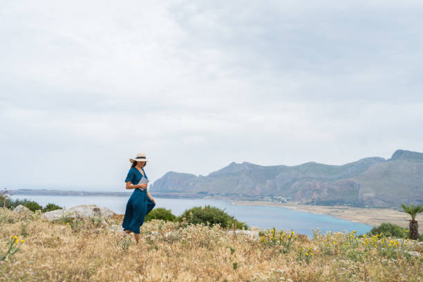 istock Young woman relaxes at coastal viewpoint 1403091852