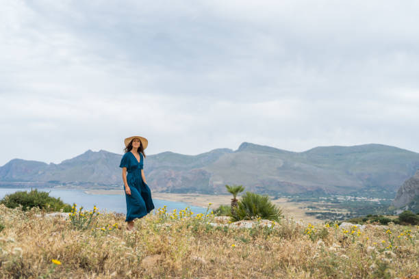 istock Young woman relaxes at coastal viewpoint 1403091887
