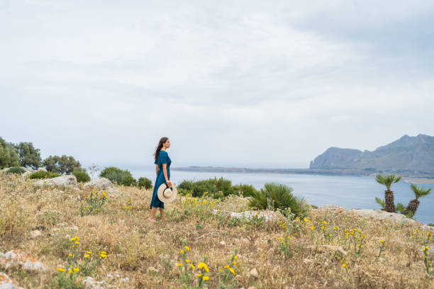 istock Young woman relaxes at coastal viewpoint 1403092012