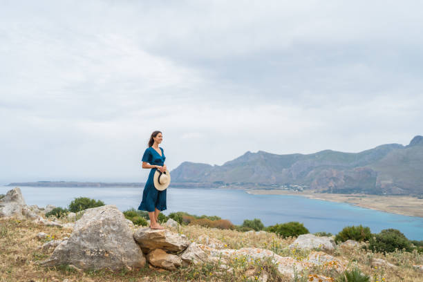 istock Young woman relaxes at coastal viewpoint 1403092036