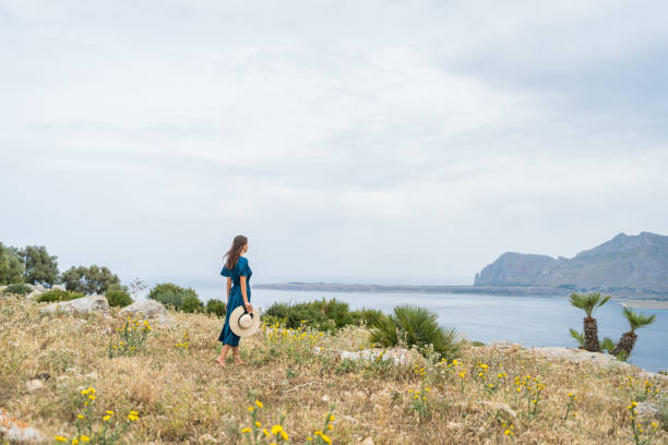 istock Young woman relaxes at coastal viewpoint 1403092037