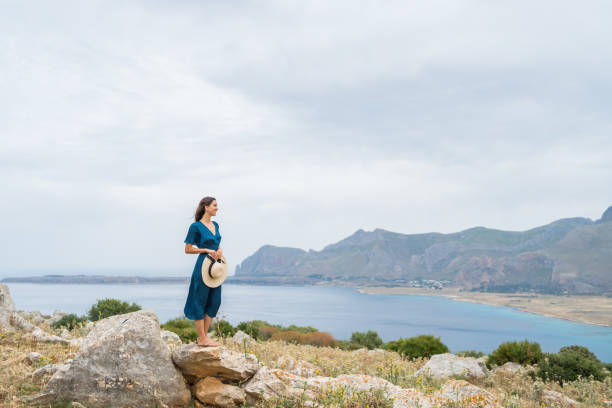 istock Young woman relaxes at coastal viewpoint 1403092047