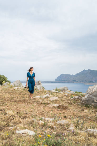 istock Young woman relaxes at coastal viewpoint 1403092118