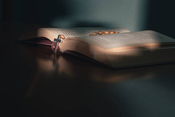 cruze sobre a bíblia sagrada em uma mesa de madeira - religious text cross protestantism reading - fotografias e filmes do acervo