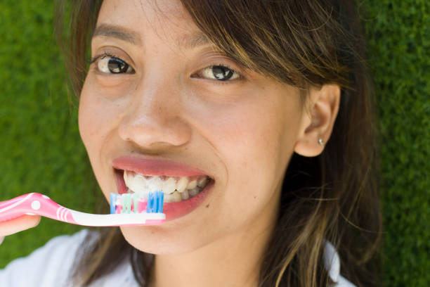 Hands of smile young Asian woman holding toothbrush