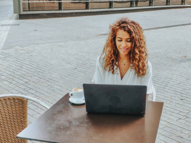 istock Businesswoman working on laptop at a cafe 1403093430