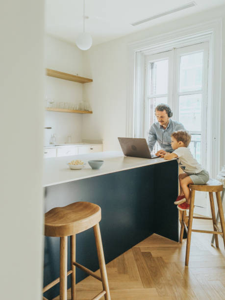istock Father working at home while taking care of his 1403093442