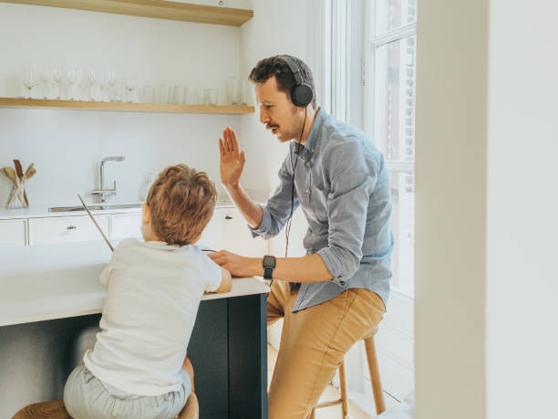 istock Father working at home while taking care of his 1403093445