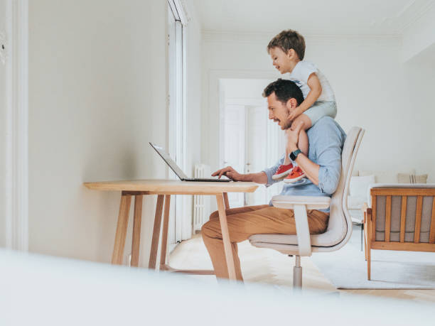 istock Father working at home while taking care of his 1403093492