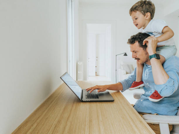 istock Father working at home while taking care of his 1403093502