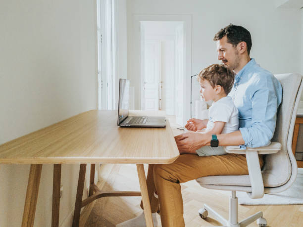 istock Father working at home while taking care of his 1403093509