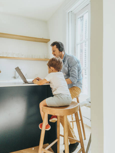 istock Father working at home while taking care of his 1403093510