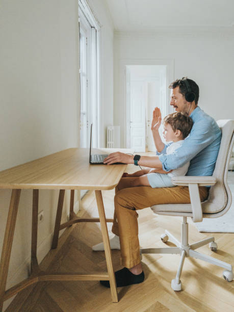 istock Father working at home while taking care of his 1403093513