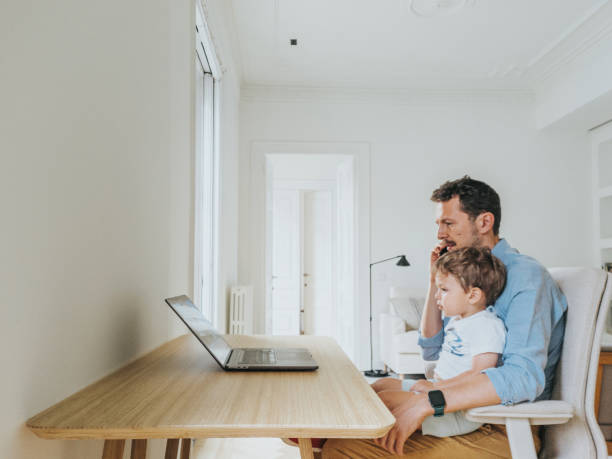 istock Father working at home while taking care of his 1403093516