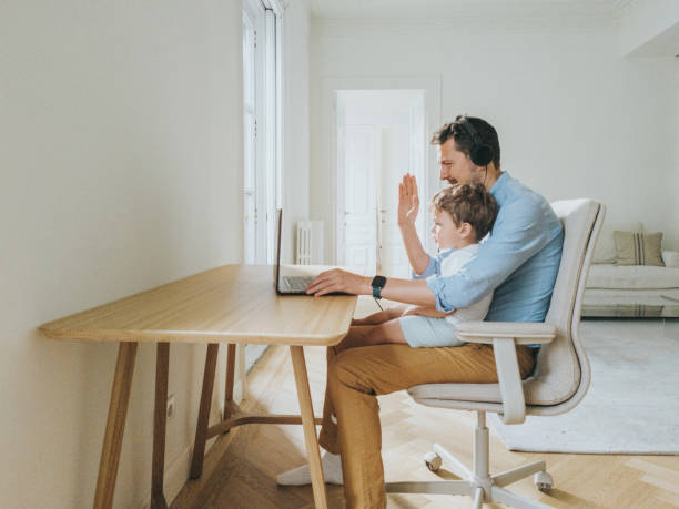 istock Father working at home while taking care of his 1403093532