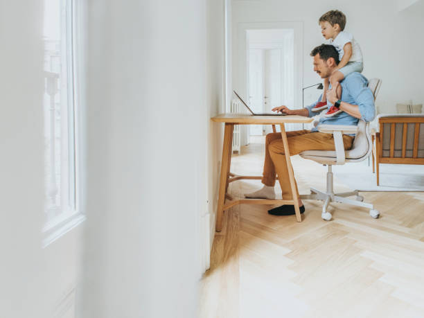 istock Father working at home while taking care of his 1403093537