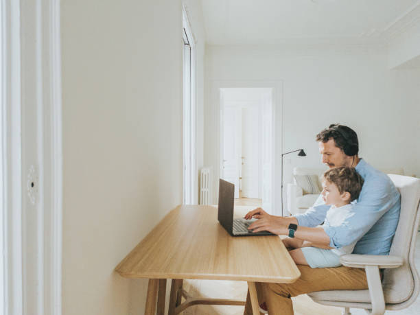 istock Father working at home while taking care of his 1403093546