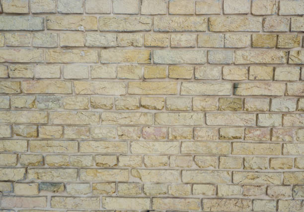 istock Peeled old brick wall. Brick yellow background. 1403094437