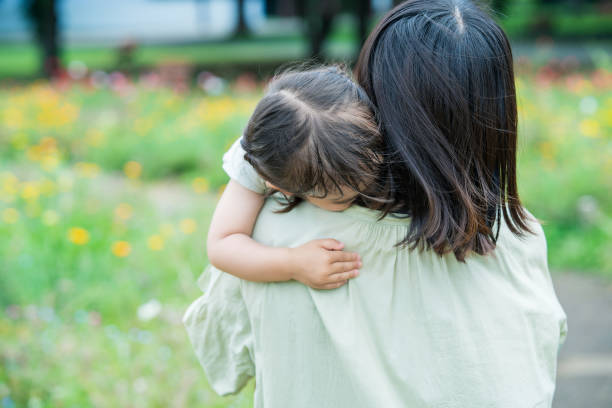 疲れて母親に抱きしめられている少女 - シングルマザー ストックフォトと画像