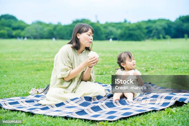 公園でサンドイッチを食べる母と娘