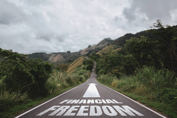 Financial freedom written on the road in the middle of asphalt road. Concept of planning and challenge or career path, business plan, strategy ,opportunity and change my life. stock photo