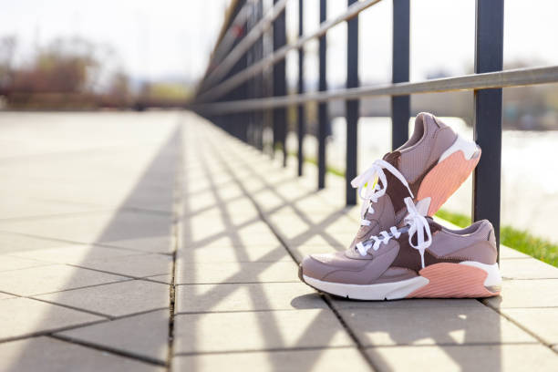 istock sneakers in bright rays of sun on paving stones 1403097429