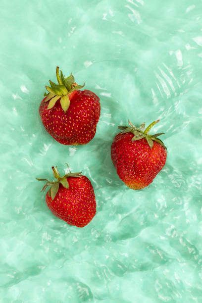 istock Fresh red strawberries in aquamarine water with waves. 1403097467